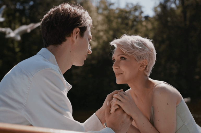 Man and woman holding hands on a boat.